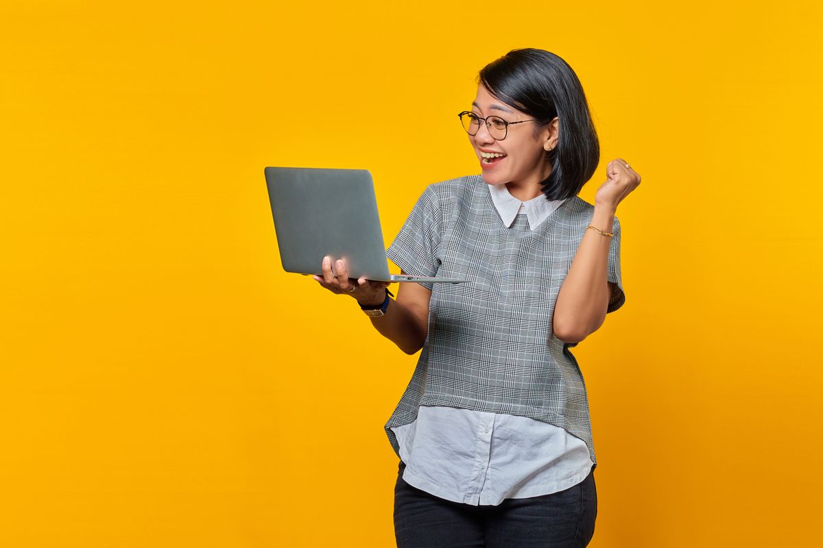 A creator looking at a growth chart on a laptop at a desk
